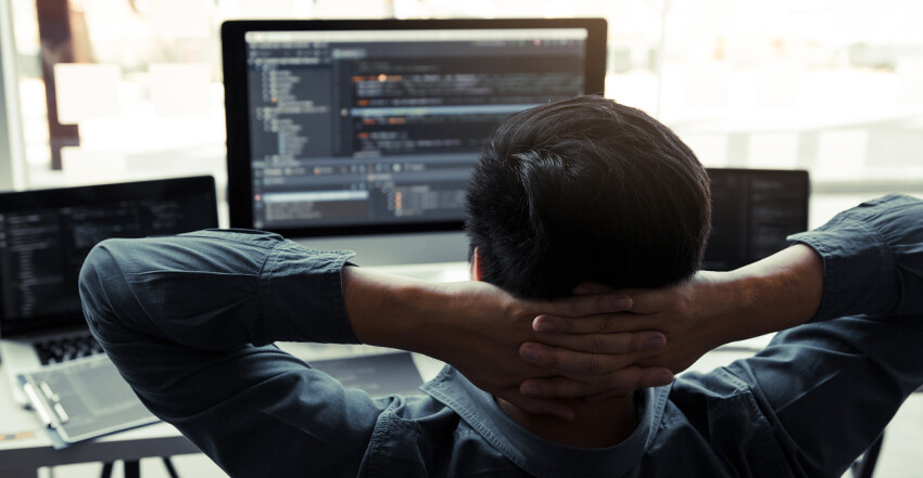 man with computer at desk - best tools for software developers